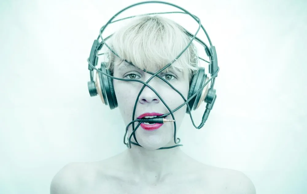 Emeraldia, casque audio et câbles enroulés autour du visage, un jack entre les lèvres